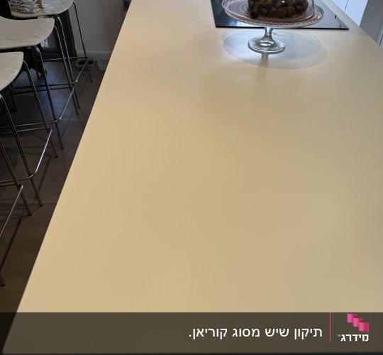 משטח שיש לבן עם עוגיות תחת כיסוי זכוכית